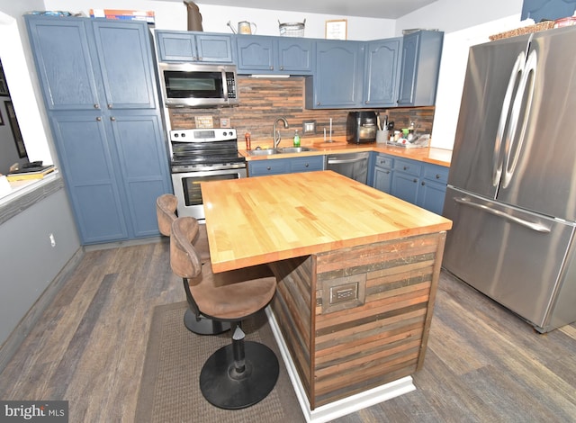 kitchen featuring blue cabinetry, stainless steel appliances, sink, and backsplash