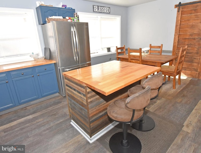 dining area with a barn door and dark hardwood / wood-style flooring