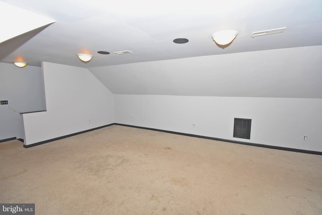 additional living space with light carpet and vaulted ceiling