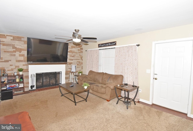 carpeted living room featuring a fireplace and ceiling fan