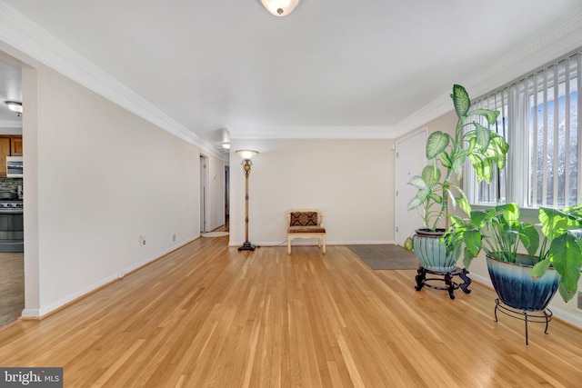 unfurnished room with light hardwood / wood-style floors and crown molding