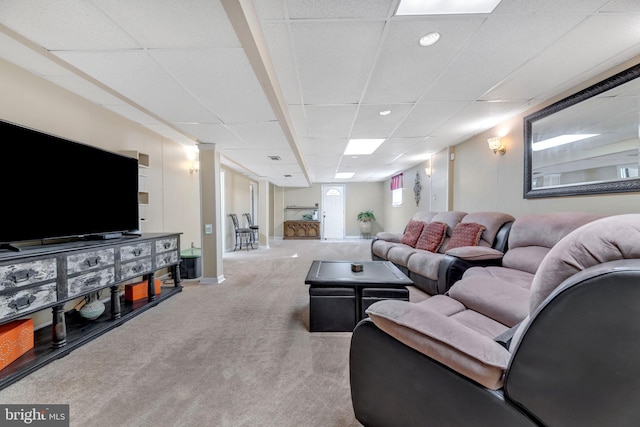 carpeted living room with a drop ceiling