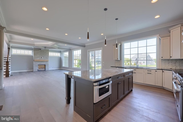 kitchen with tasteful backsplash, a healthy amount of sunlight, a fireplace, and a sink