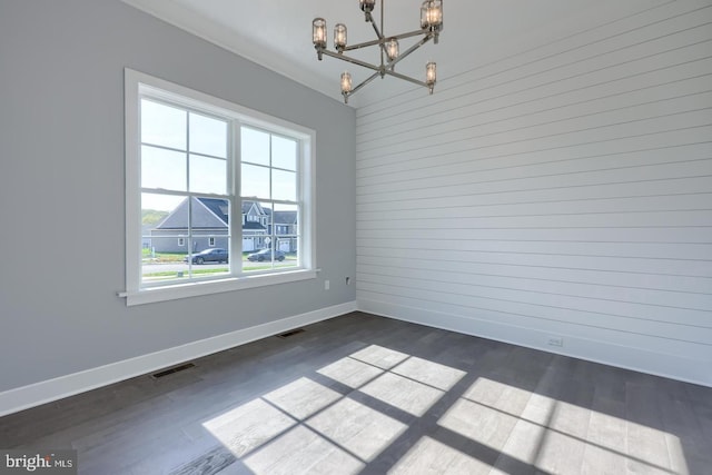 unfurnished dining area featuring baseboards, dark wood-style flooring, visible vents, and a notable chandelier