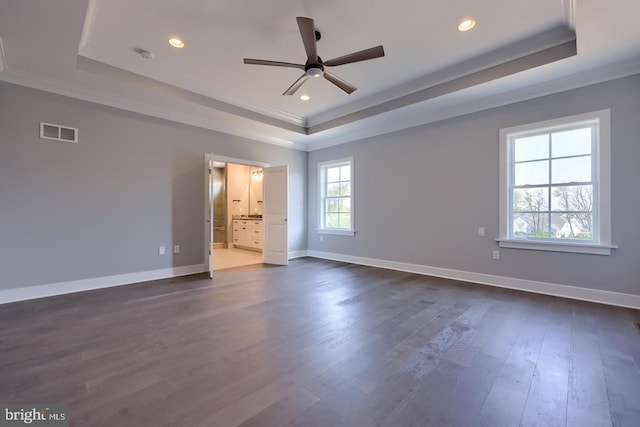 unfurnished bedroom featuring ornamental molding, a tray ceiling, and visible vents