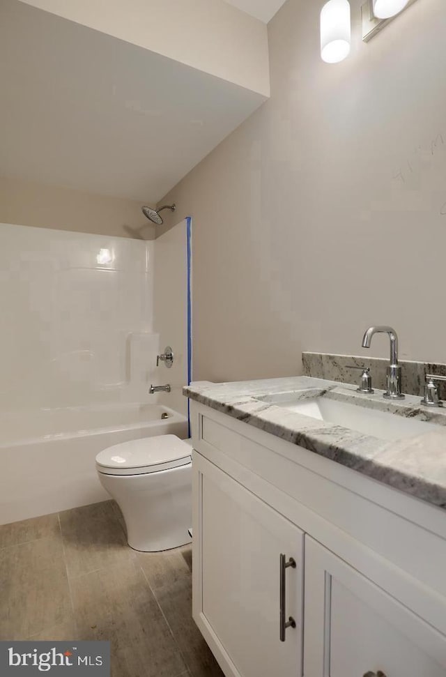 bathroom with toilet,  shower combination, and vanity