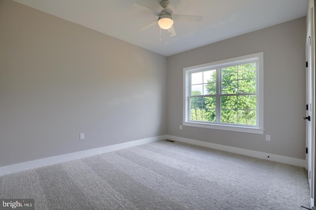 spare room featuring ceiling fan, carpet floors, visible vents, and baseboards