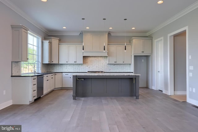 kitchen featuring a sink, crown molding, stainless steel dishwasher, and a center island