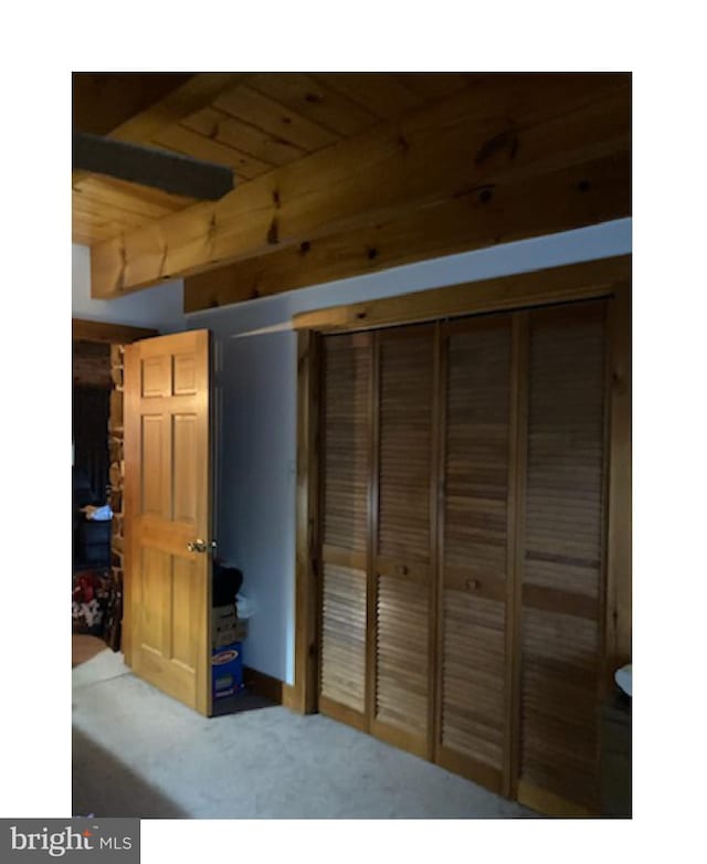 bedroom featuring a closet, carpet floors, and wood ceiling