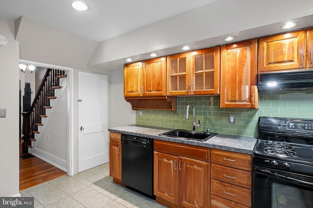 kitchen with lofted ceiling, decorative backsplash, light tile patterned floors, black appliances, and sink