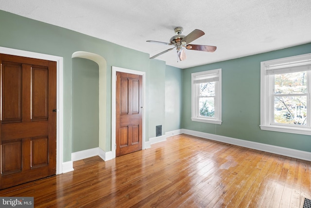 unfurnished bedroom with a textured ceiling, light wood-type flooring, and ceiling fan