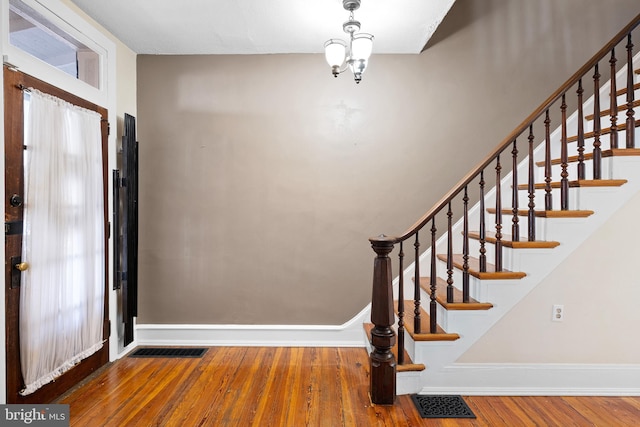 foyer entrance featuring hardwood / wood-style floors and a notable chandelier