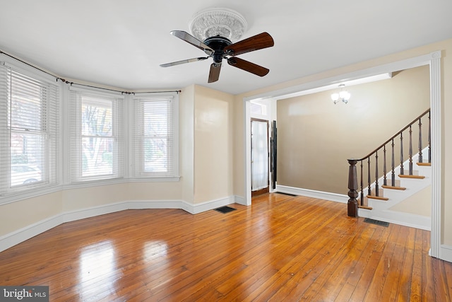 unfurnished living room with wood-type flooring and ceiling fan