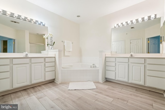 bathroom featuring vanity, independent shower and bath, and wood-type flooring