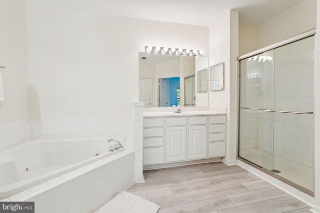 bathroom featuring vanity, hardwood / wood-style flooring, and shower with separate bathtub