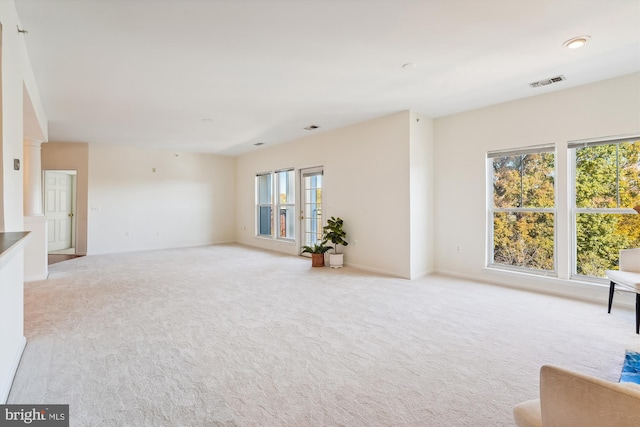 unfurnished living room featuring light colored carpet