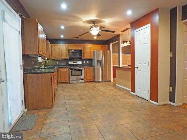 kitchen with sink, decorative light fixtures, stainless steel appliances, and ceiling fan