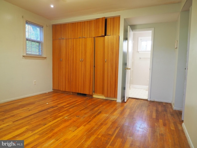 unfurnished bedroom featuring a closet and hardwood / wood-style flooring