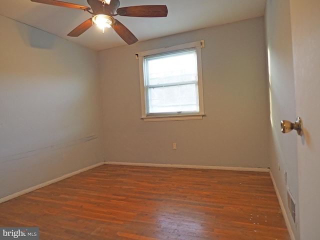 empty room with ceiling fan and dark hardwood / wood-style flooring