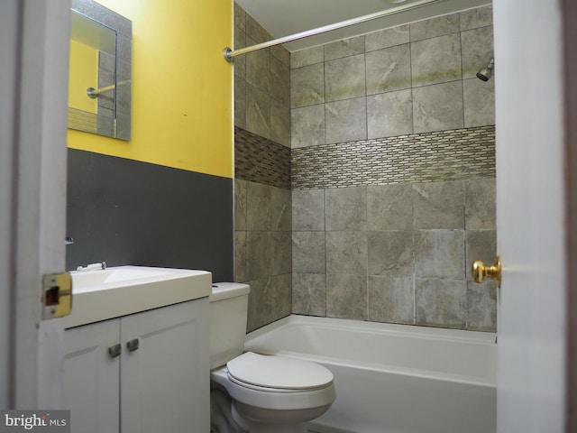 full bathroom with tiled shower / bath, vanity, and toilet