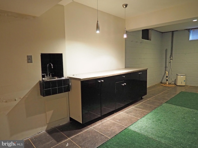 interior space featuring sink, decorative light fixtures, and dark tile patterned flooring