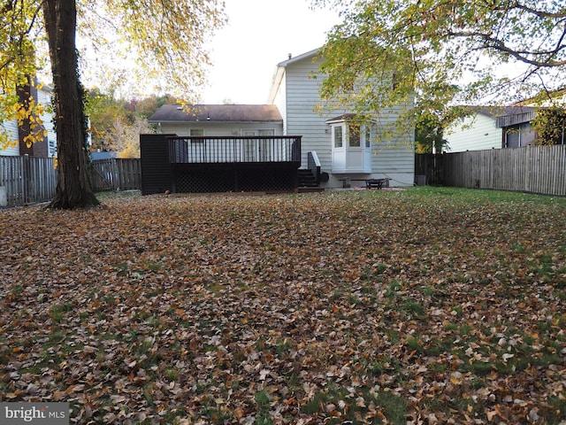 rear view of house featuring a wooden deck