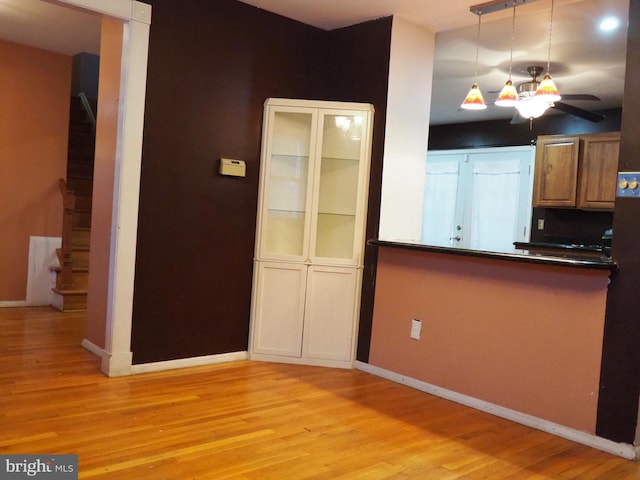 kitchen with decorative light fixtures, light hardwood / wood-style floors, and ceiling fan