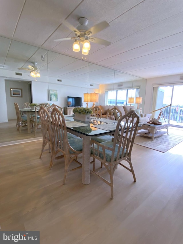 dining area with ceiling fan and hardwood / wood-style flooring