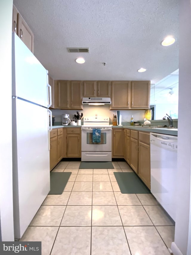 kitchen featuring light tile patterned floors, white appliances, light brown cabinets, and a textured ceiling