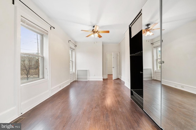 interior space featuring ceiling fan, crown molding, and dark hardwood / wood-style flooring