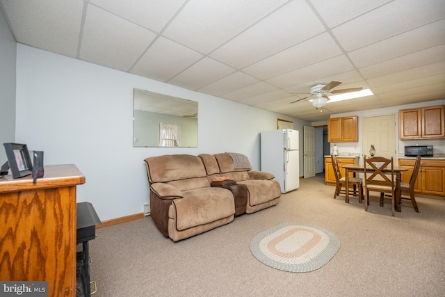 carpeted living room featuring a paneled ceiling and ceiling fan