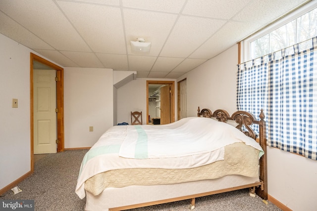 carpeted bedroom with a paneled ceiling