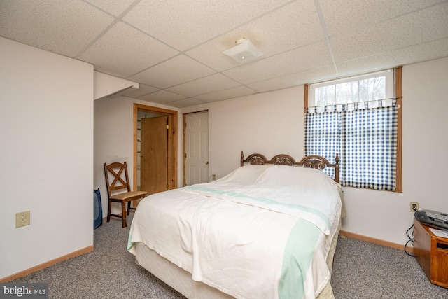 carpeted bedroom featuring a drop ceiling