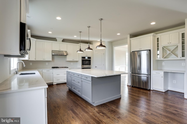 kitchen featuring a kitchen island, dark hardwood / wood-style floors, stainless steel appliances, sink, and white cabinetry