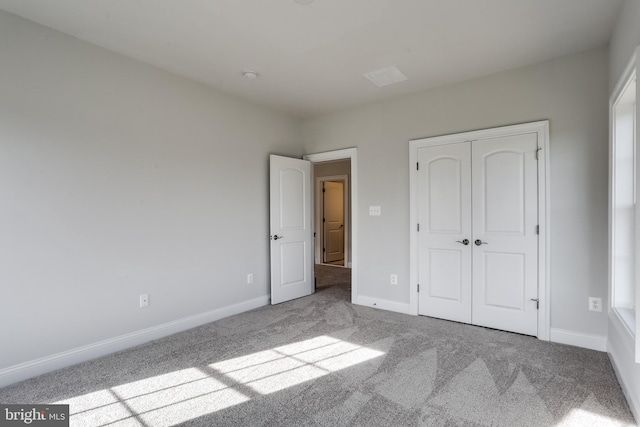 unfurnished bedroom featuring a closet and light carpet