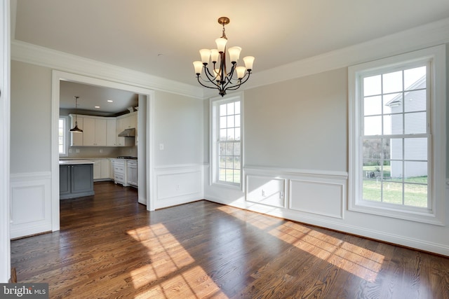 unfurnished dining area featuring a healthy amount of sunlight, a chandelier, and dark hardwood / wood-style flooring