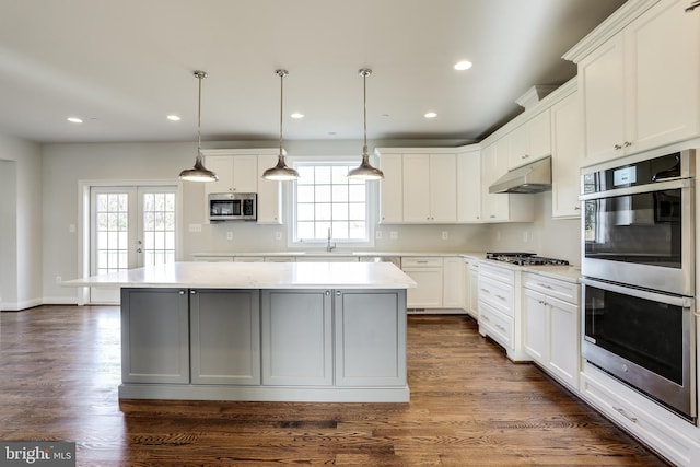 kitchen featuring white cabinets, a healthy amount of sunlight, stainless steel appliances, and a kitchen island