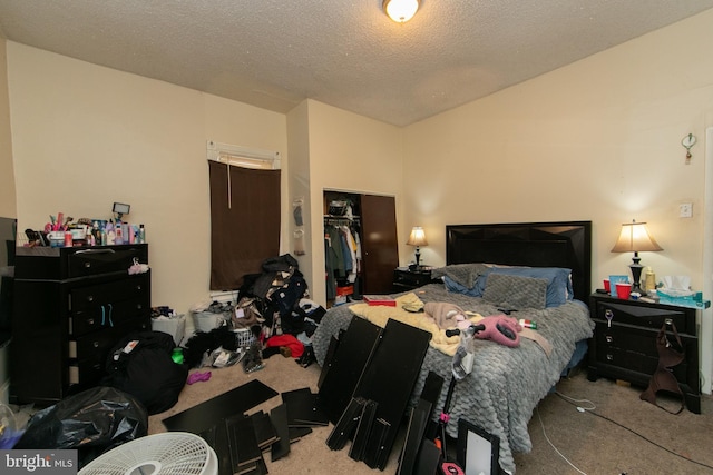 bedroom with a textured ceiling, a spacious closet, light carpet, and a closet