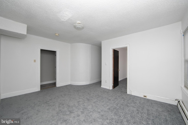 carpeted empty room with a textured ceiling and baseboard heating