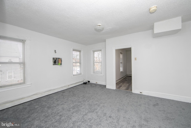 carpeted spare room with a textured ceiling and baseboard heating