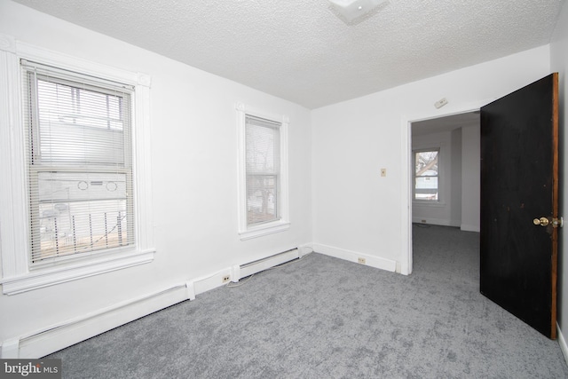 carpeted spare room with a textured ceiling and baseboard heating