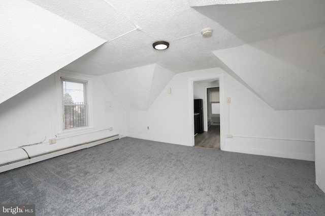 bonus room with dark colored carpet, a textured ceiling, a baseboard radiator, and vaulted ceiling