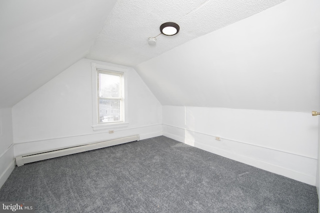 bonus room featuring a textured ceiling, dark carpet, lofted ceiling, and baseboard heating