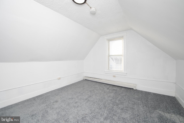 bonus room featuring dark carpet, a textured ceiling, a baseboard radiator, and vaulted ceiling