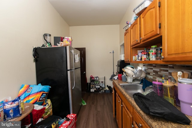 kitchen featuring stainless steel fridge, backsplash, dark wood-type flooring, and sink