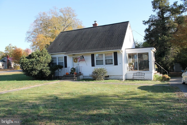 cape cod house with a sunroom and a front yard