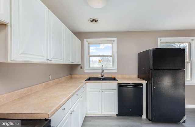 kitchen with sink, white cabinets, and black appliances