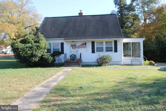 new england style home featuring a front lawn and a sunroom