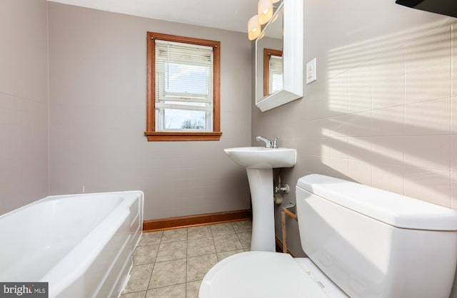 bathroom with toilet, sink, tile patterned flooring, and a bathing tub