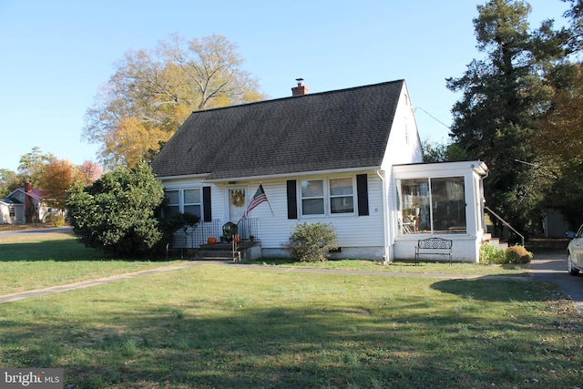 cape cod house featuring a front yard